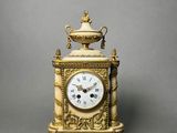 a gold clock that is sitting on a table