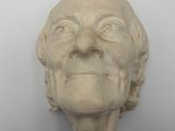 sculpture of a man ' s face on a wall with a white background