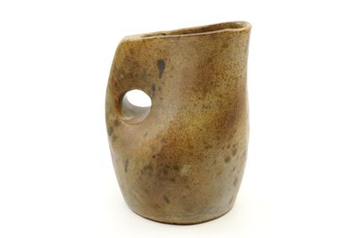 a brown vase with a hole in it on a white surface
