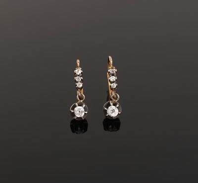 a pair of diamond earrings on a black surface