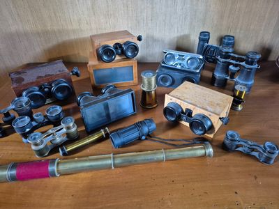 many different types of binoculars on a wooden table