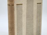 un vieux livre posé sur une table à côté d'un mur blanc