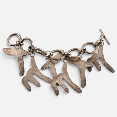 un gros plan sur un bracelet en métal orné de cinq breloques