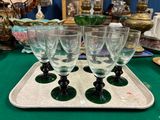 quatre verres à vin posés sur un plateau, sur une table