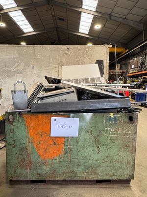 une grande caisse métallique sur laquelle est posé un ordinateur portable, dans un entrepôt