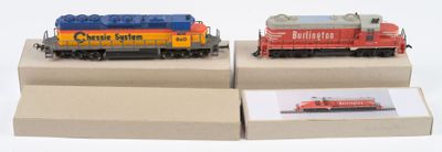 deux trains miniatures exposés sur une surface blanche