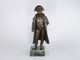 statue en bronze représentant un homme coiffé d'un chapeau et vêtu d'un manteau, debout sur un socle en marbre