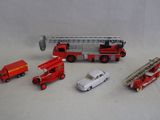 un camion de pompiers miniature, une voiture et d'autres véhicules miniatures posés sur une table