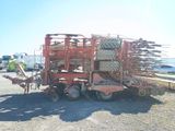 an image of a tractor with a trailer loaded with a loader