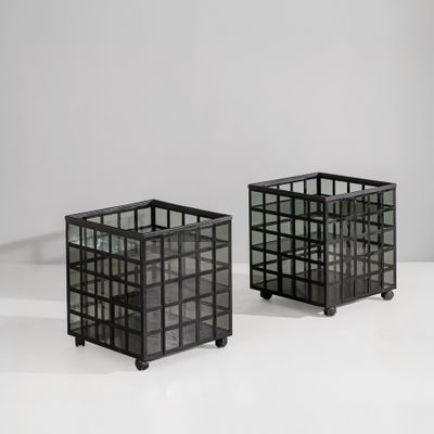 pair of black glass cube planters on casteors on a white surface