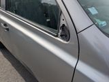 a silver car with a sticker on the side of it ' s door