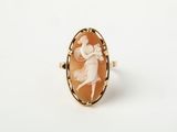 un gros plan sur une bague ornée de l'image d'une femme en robe
