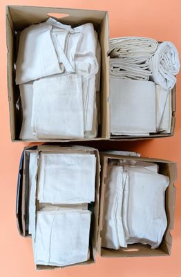 des boîtes remplies de tissus blancs posées sur une surface rose