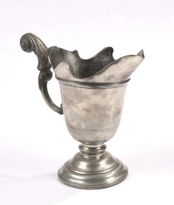 a silver cup with a handle on a pedestal