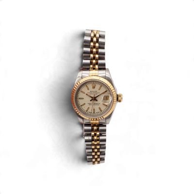 une photo d'une montre Rolex pour femme posée sur une surface blanche