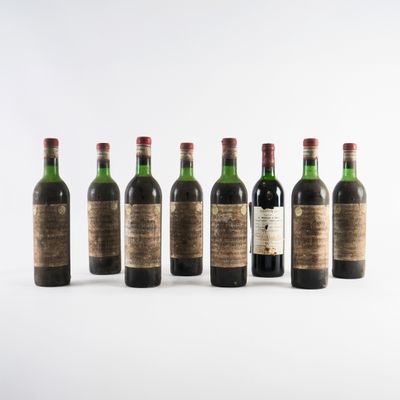 six bouteilles de vin alignées sur une surface blanche