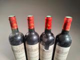 four bottles of wine are lined up in a row on a table