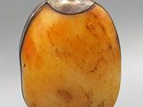 une photo d'une bouteille en verre orange avec un bouchon argenté