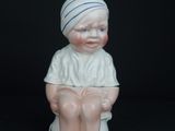 a small figurine of a boy sitting on a glass table