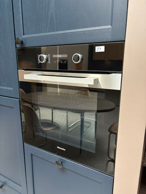 un four au milieu d'une cuisine aux placards bleus