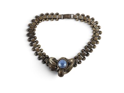 un gros plan sur un bracelet orné d'une pierre bleue