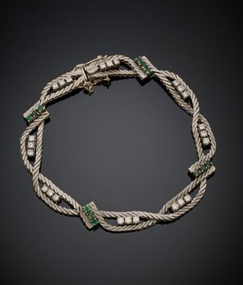 un bracelet en argent orné d'émeraudes et de perles sur fond noir