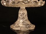a clear glass cake plate on a black table