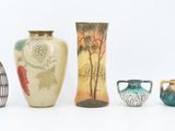 five different vases sitting next to each other on a white surface