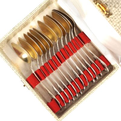 un ensemble de cuillères et de fourchettes argentées et rouges dans un coffret