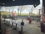 une grande terrasse équipée de tables et de parasols