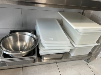 a stainless steel counter with a bowl and a pan on it