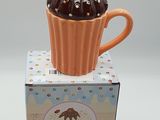 un cupcake posé sur une boîte, surmonté d'une tranche d'orange