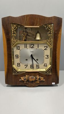 a small wooden clock with a bell on top of it