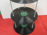a three tiered display of vinyl records on a red floor