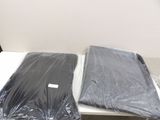 two laptops sitting on a table covered in plastic