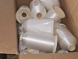 a cardboard box filled with many rolls of white thread
