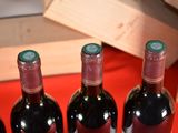 several bottles of wine are lined up on a red table