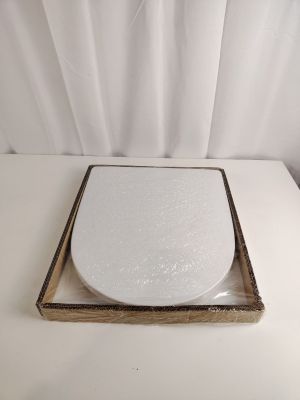 des toilettes blanches avec un couvercle en bois posées sur une table blanche