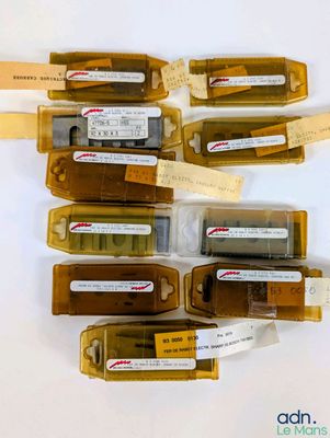 six bouteilles d'alcool posées sur une table, avec des étiquettes dessus