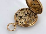 an image of a gold pocket watch on a white surface