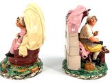 two figurines of a man and a woman sitting on a bench