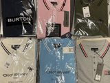 six men ' s polo shirts in plastic bags on a table