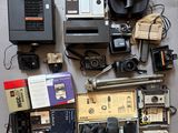 beaucoup de vieux appareils photo et d'autres appareils électroniques posés sur une table
