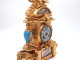 a gold clock with a blue and gold decoration on it