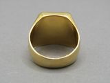 a close up of a gold ring on a gray surface
