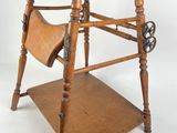 a wooden high chair with a magazine rack on it