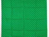 une pochette à motifs de pois verts et noirs sur fond blanc