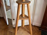 une table en bois sur laquelle est posé un tabouret, dans une pièce