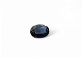 a close up of a blue sapphire stone on a white surface