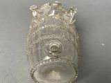 a small glass bottle with a crown on top of it